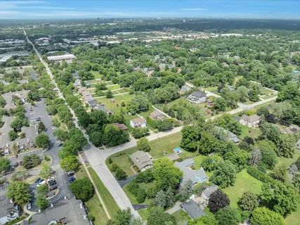 an aerial view of residential houses with outdoor space and trees