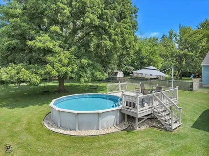 a view of a wooden chairs and table in the grass