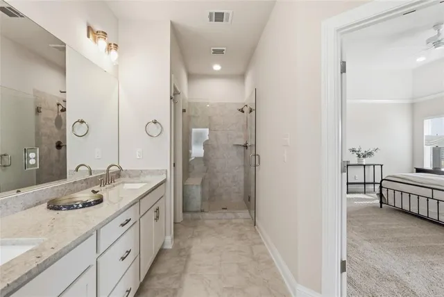 a spacious bathroom with a double vanity sink a large mirror and shower