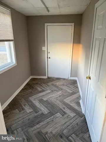 a view of a room with wooden floor and a window
