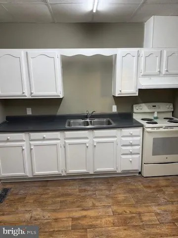 a kitchen with granite countertop white cabinets and white appliances