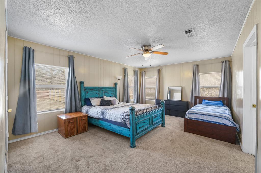 1145 Jefferson Road Paris, TX 75460 - Photo 13 of 17 a spacious bedroom with a bed and a chandelier