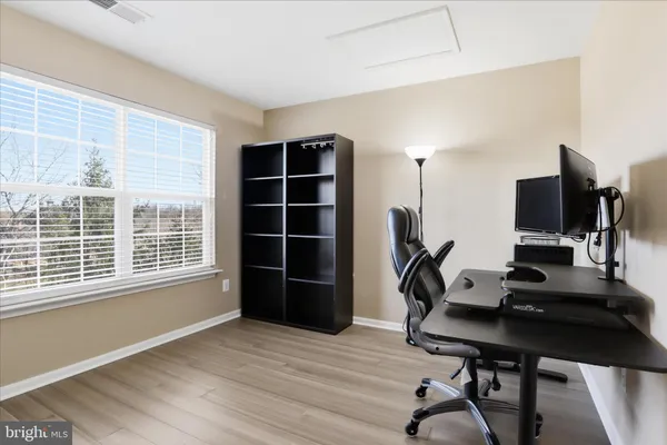 a view of empty room with wooden floor and chair