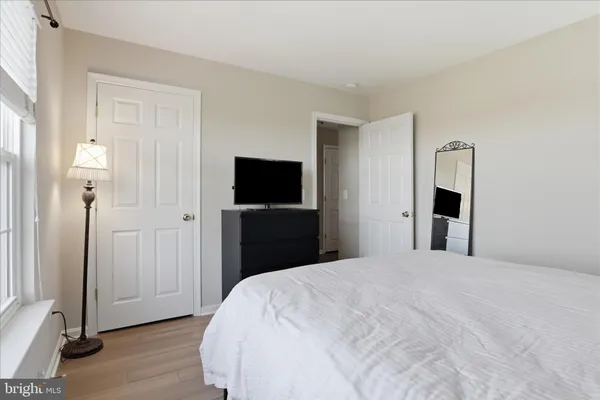 a bedroom with a bed and wooden floor