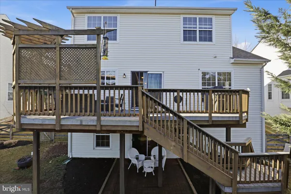 a view of a house with wooden deck and furniture