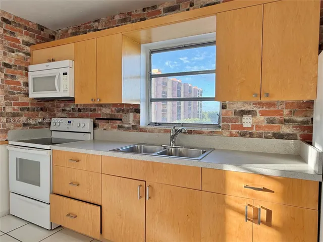 a kitchen with stainless steel appliances granite countertop a sink and a stove