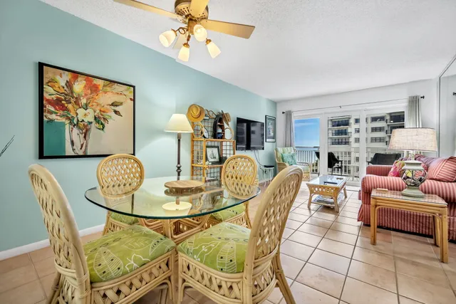 a living room with furniture a dining table and a chandelier