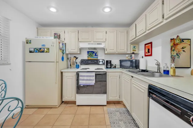 a kitchen with stainless steel appliances a refrigerator sink and white cabinets