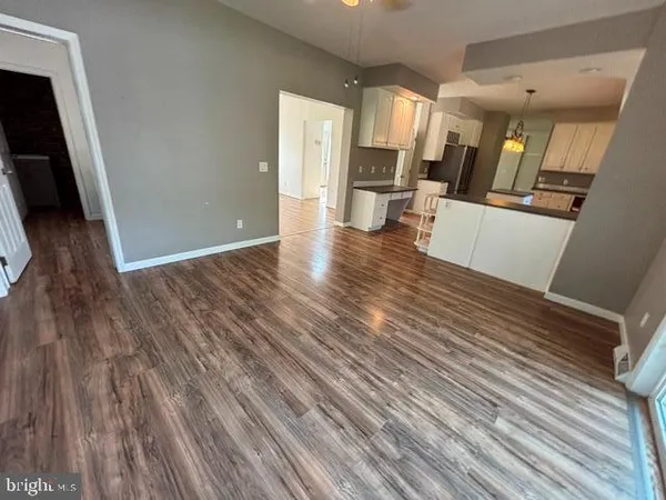 a view of a living hall with wooden floor and furniture