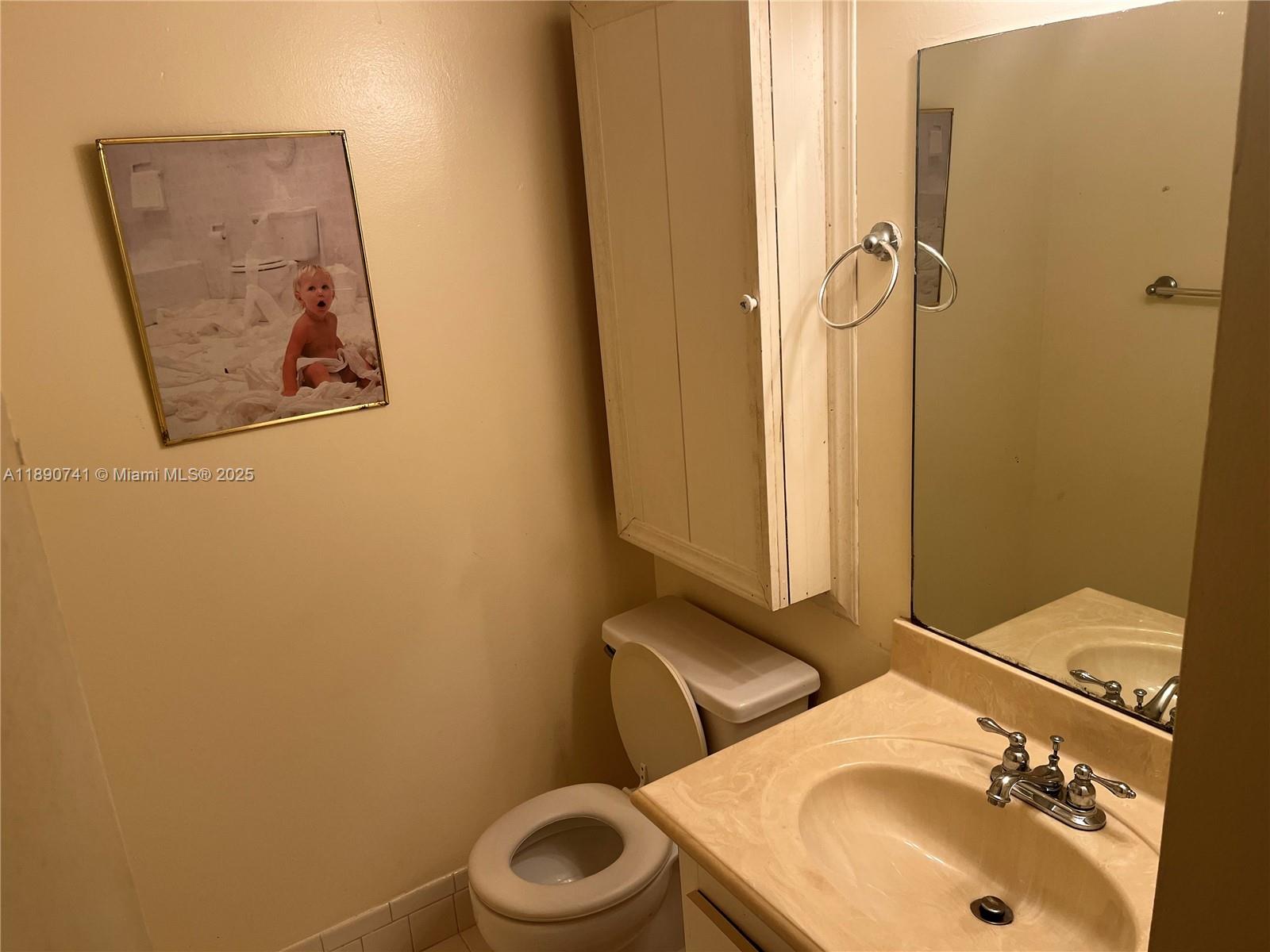 150 Southwest 134th Way, Unit 209R Pembroke Pines, FL 33027 - Photo 10 of 12 a bathroom with a sink and mirror with toilet