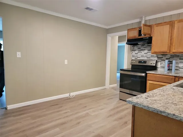 a kitchen with granite countertop a sink and a stove top oven