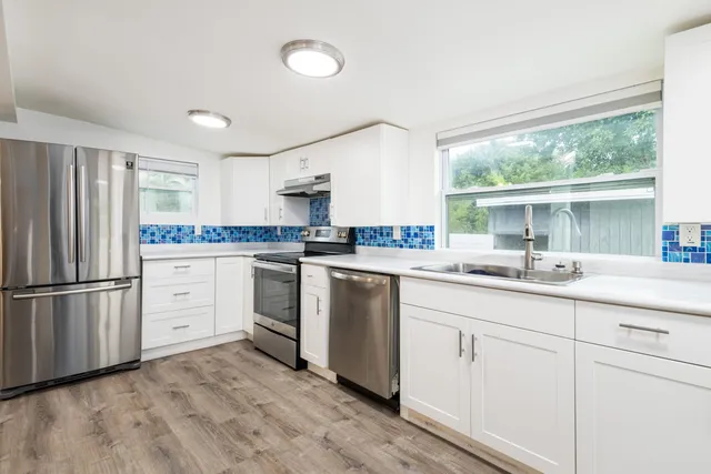 a kitchen with white cabinets and white appliances