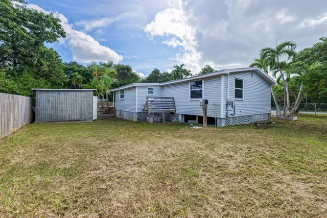 a view of a house with a backyard and wooden fence