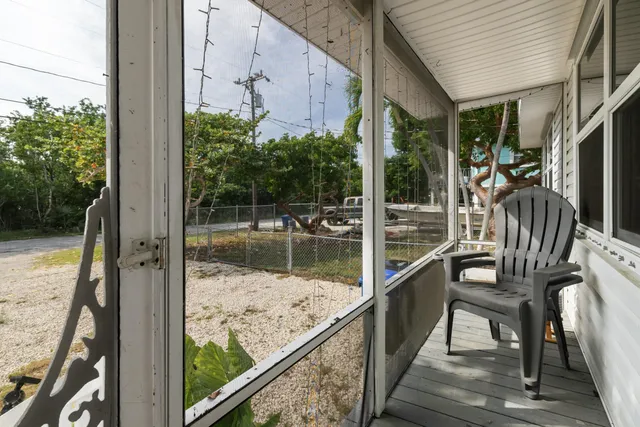 a view of a balcony with chair and wooden floor