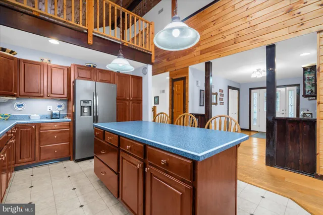 a kitchen with stainless steel appliances granite countertop a kitchen island a refrigerator and a sink
