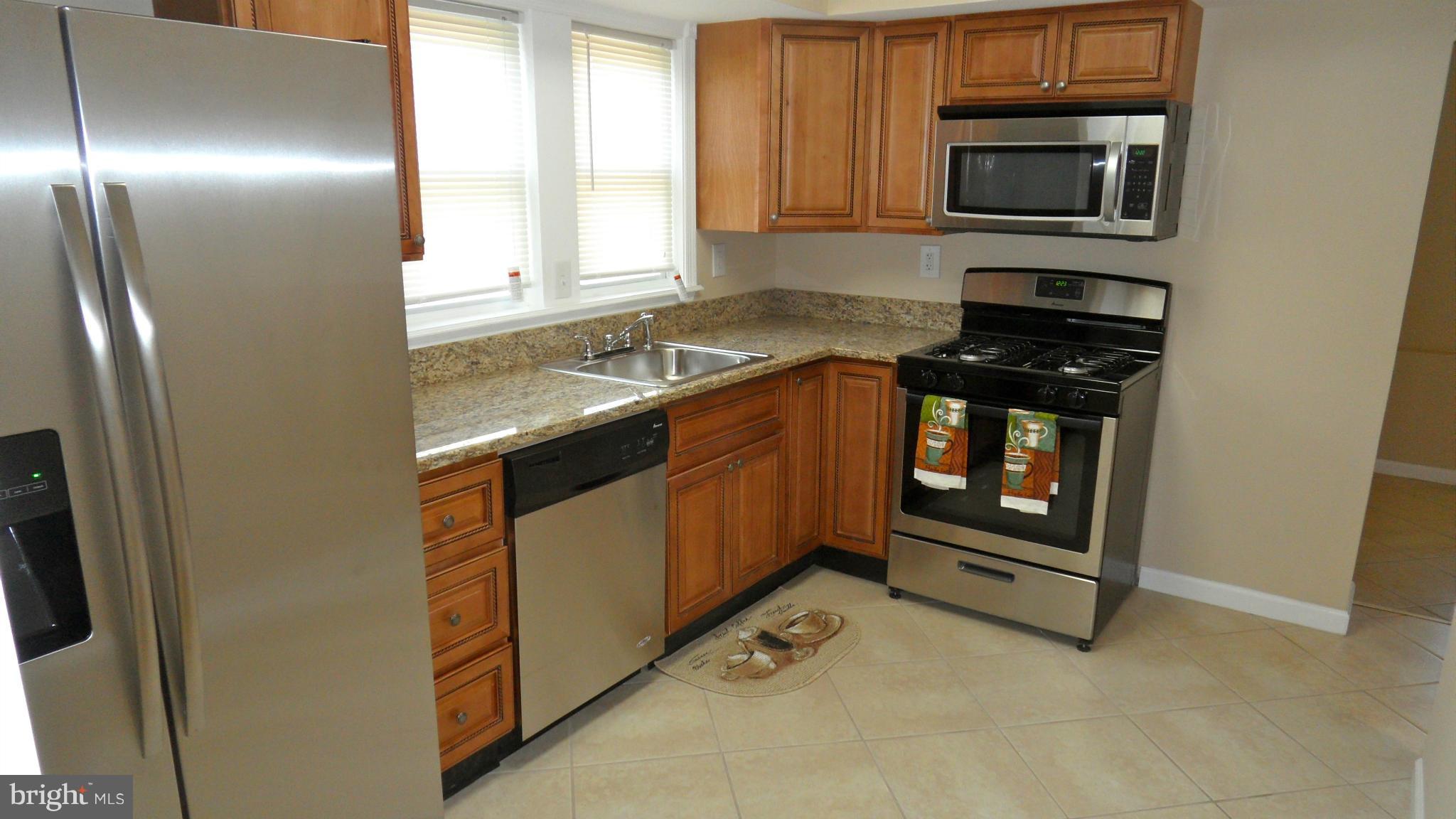 3604 Florida Road Baltimore, MD 21244 - Photo 5 of 28 a kitchen with stainless steel appliances granite countertop a stove a microwave and a refrigerator