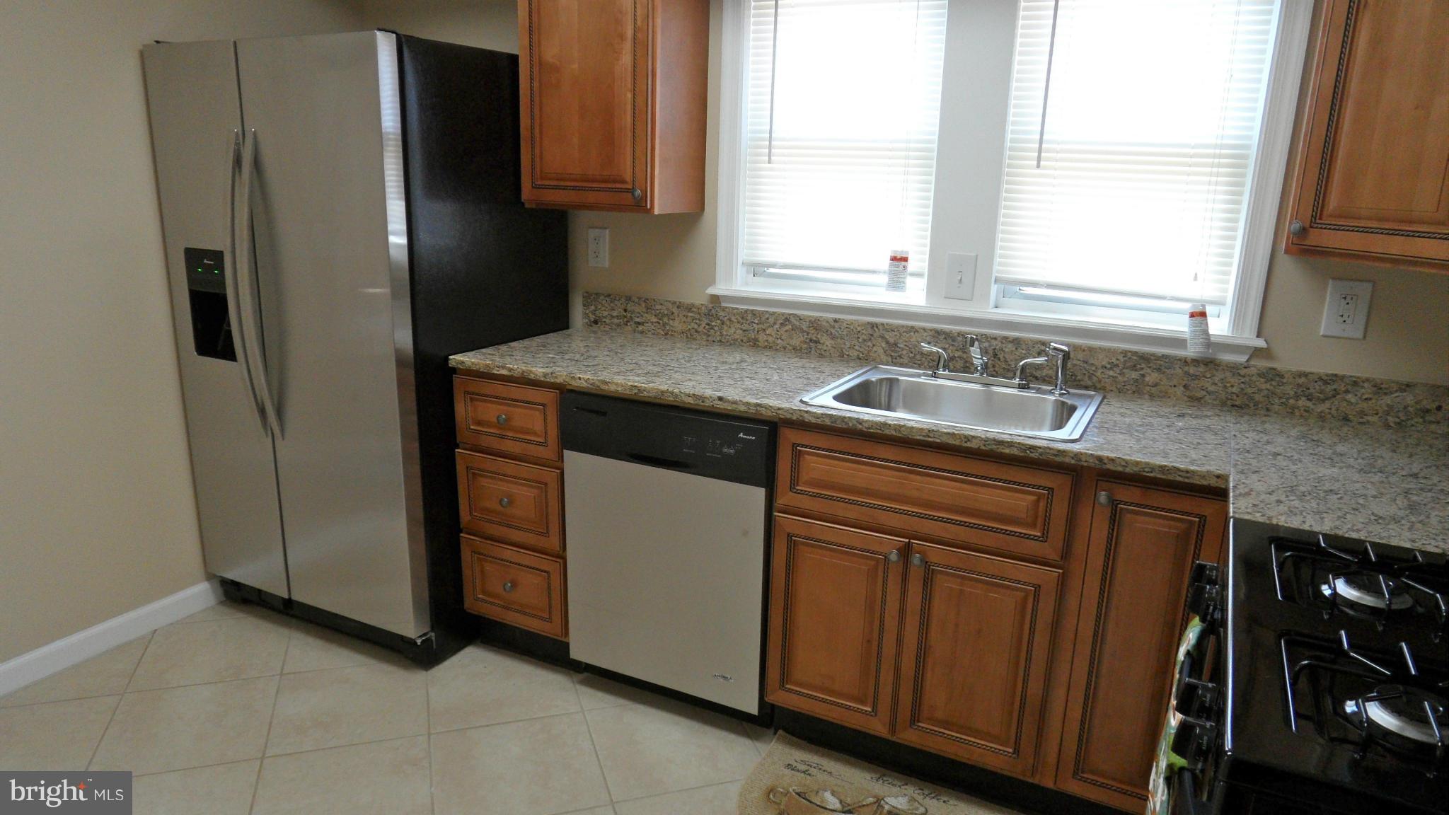 3604 Florida Road Baltimore, MD 21244 - Photo 7 of 28 a kitchen with stainless steel appliances granite countertop a refrigerator and a sink