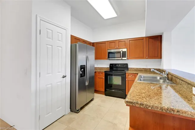 a kitchen with granite countertop a refrigerator stove and oven
