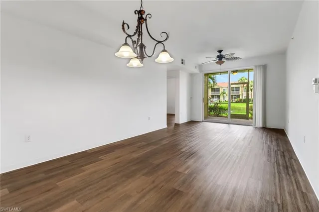 a view of a room with wooden floor exposed radiator and windows