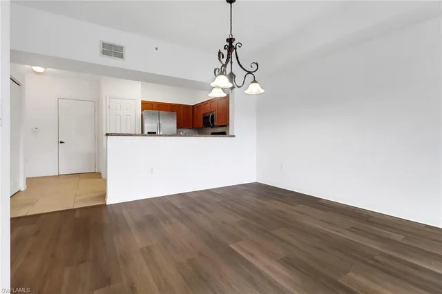 a view of a room with wooden floor staircase and a chandelier