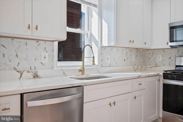a kitchen with stainless steel appliances granite countertop a sink and cabinets