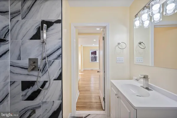 a bathroom with a sink a mirror and shower