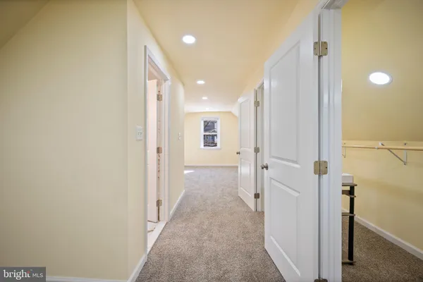 a view of a hallway with wooden shelves