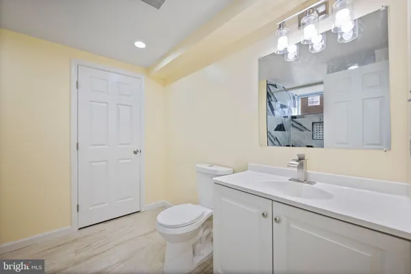 a bathroom with a sink a toilet and a mirror