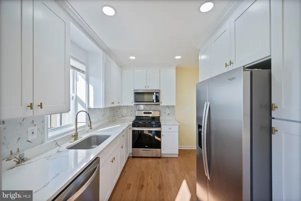 a kitchen with stainless steel appliances granite countertop a refrigerator sink and stove