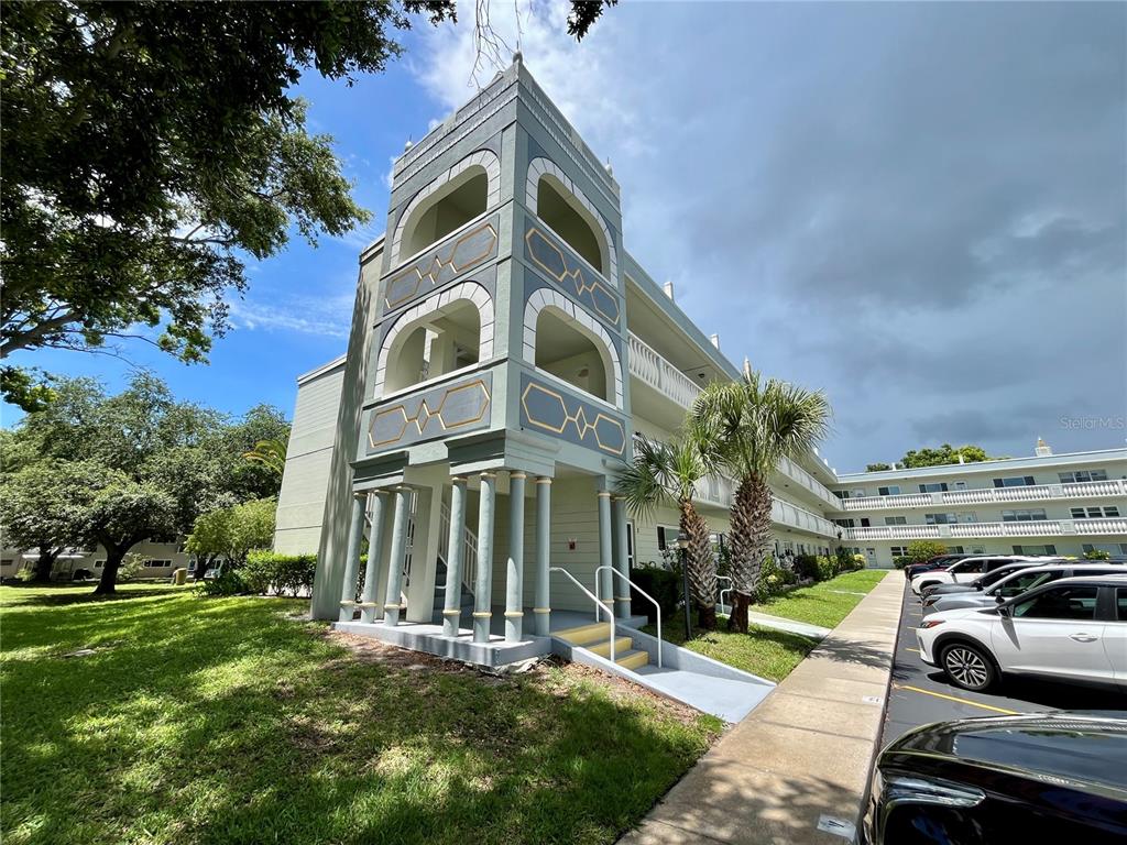 2292 Costa Rican Drive, Unit 22 Clearwater, FL 33763 - Photo 1 of 44 a front view of a residential apartment building with a yard