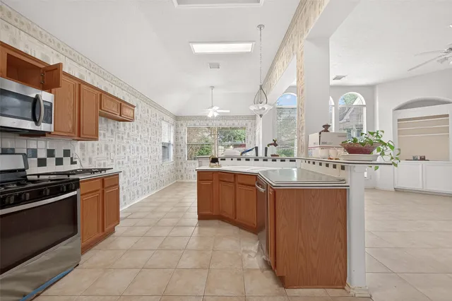 a kitchen with stainless steel appliances granite countertop a sink counter space cabinets and a stove