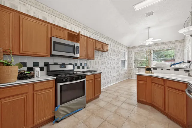 a kitchen with stainless steel appliances granite countertop a stove sink and microwave