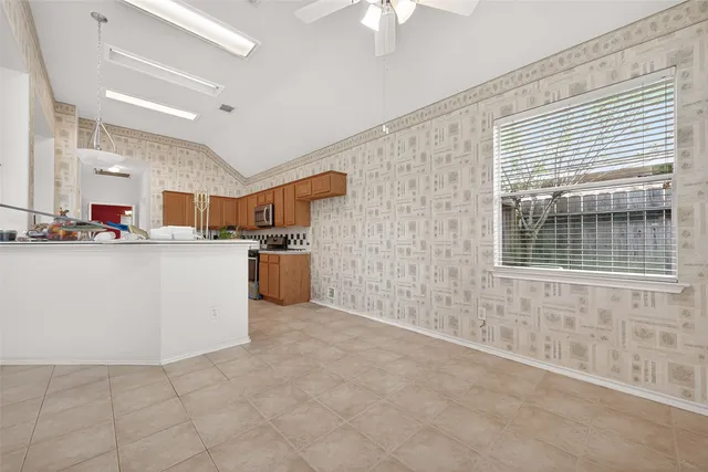 a living room with stainless steel appliances kitchen island granite countertop a sink and cabinets