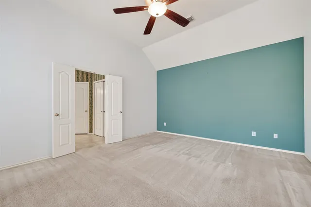 an empty room and chandelier fan