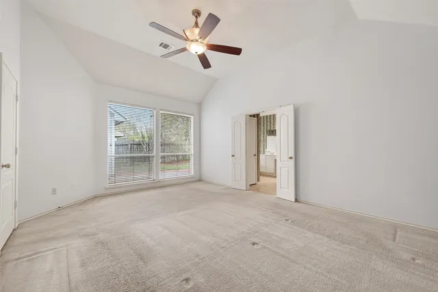 an empty room with a ceiling fan and window