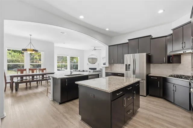 a kitchen with stainless steel appliances granite countertop a sink stove and refrigerator