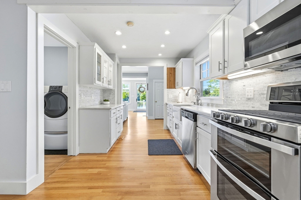 35 Keyes Road Westford, MA 01886 - Photo 11 of 40 a kitchen with kitchen island a counter top space a stove a refrigerator cabinets and a sink