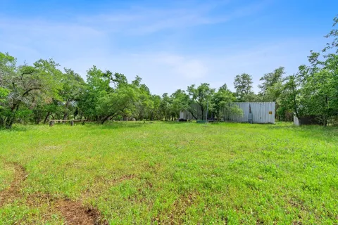 a view of a lush green field with a view of mountains in the background
