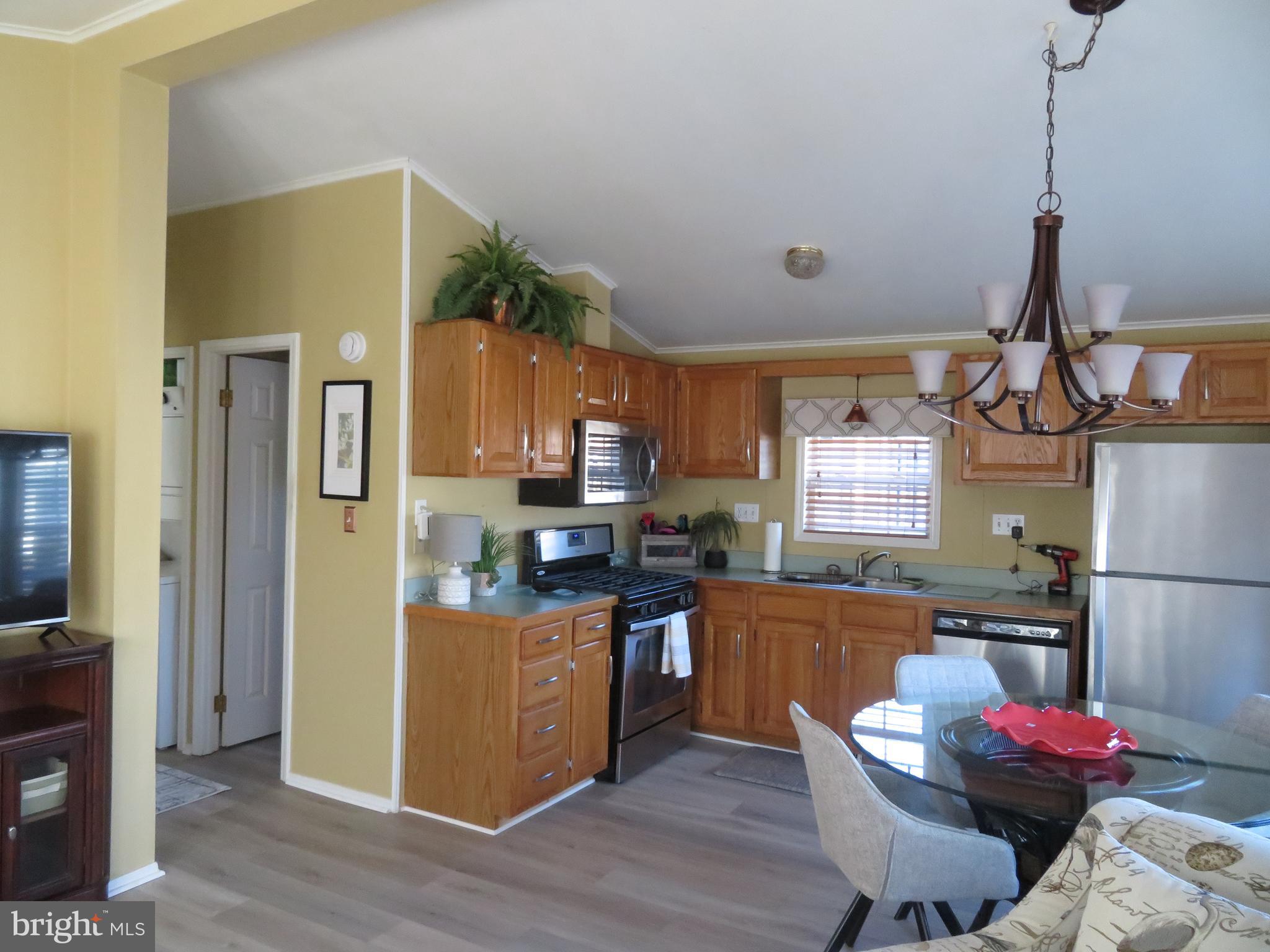 120 Skipjack Circle Berlin, MD 21811 - Photo 22 of 91 a kitchen with stainless steel appliances granite countertop a refrigerator a sink dishwasher a stove with wooden cabinets and floor