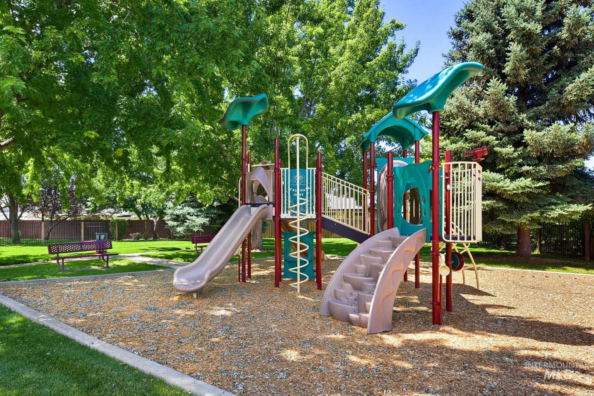 2172 West Cedar Grove Street Meridian, ID 83646 - Photo 43 of 49 Outdoor playground featuring a multi-component play structure with slides and climbing elements, surrounded by mature trees