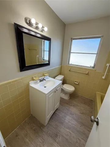 a bathroom with a sink mirror vanity and toilet