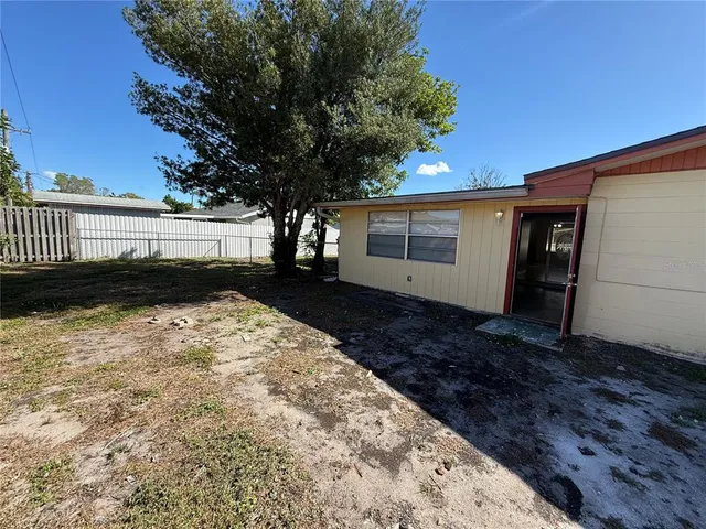 a view of backyard with wooden fence and large trees
