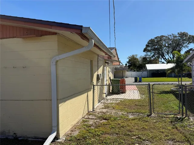 a view of a chair and table in backyard of the house