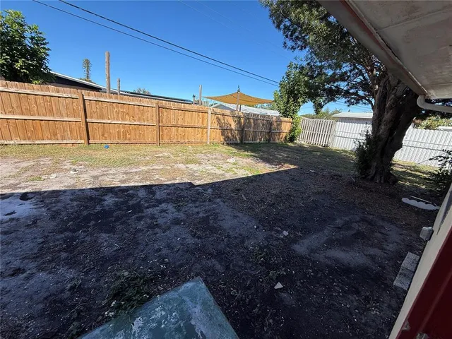a view of a backyard with floor to ceiling window and tree