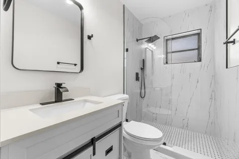 a bathroom with a sink a toilet and shower