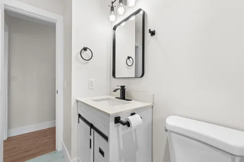 a bathroom with a sink a toilet and a mirror