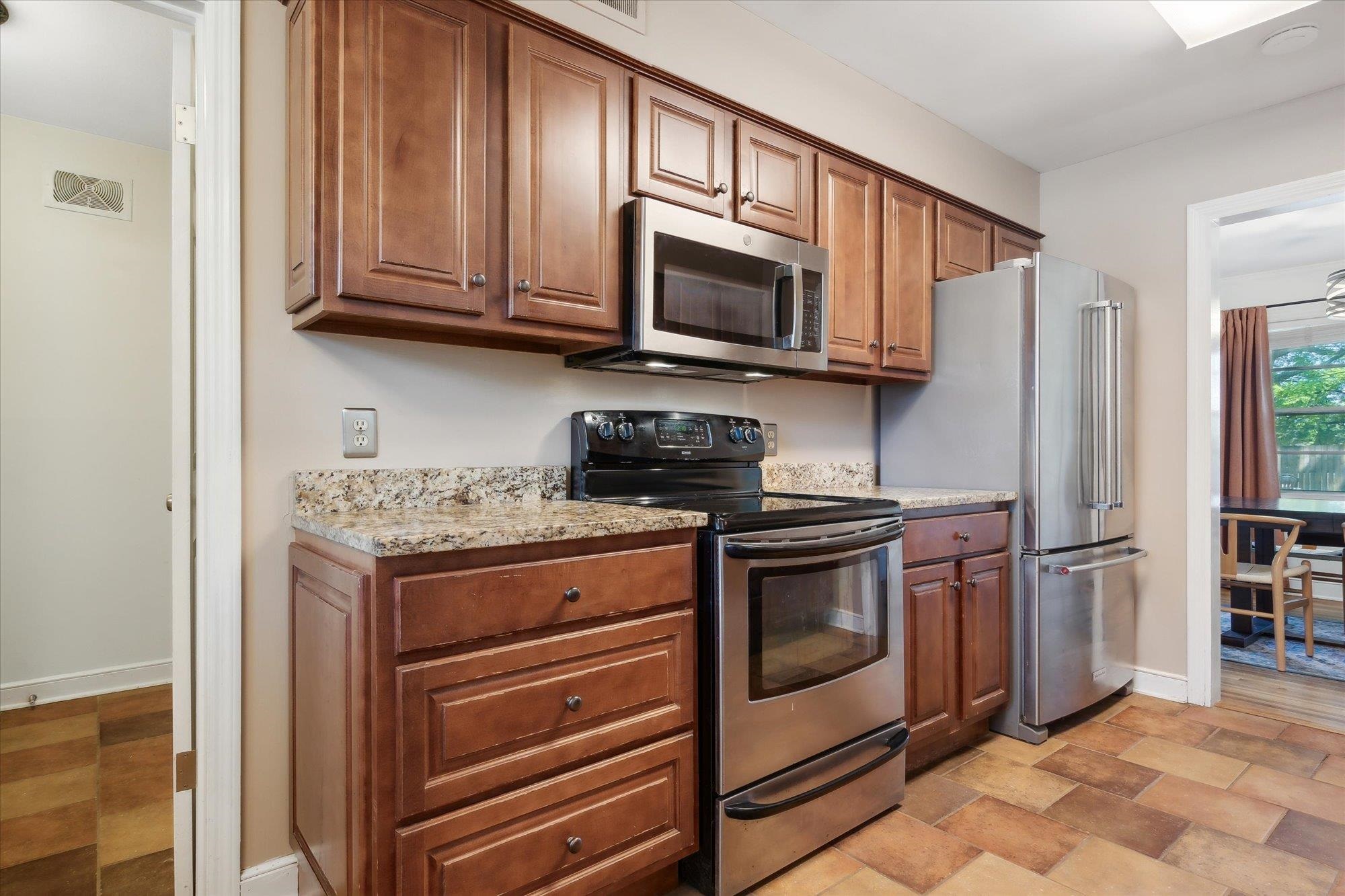 336 McElroy Road Memphis, TN 38120 - Photo 10 of 26 Kitchen featuring light tile patterned flooring, light stone counters, and stainless steel appliances