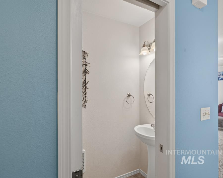 1337 Bristol Road Moscow, ID 83843 - Photo 3 of 28 Pedestal sink with oval mirror, wall-mounted light fixture, and two towel rings