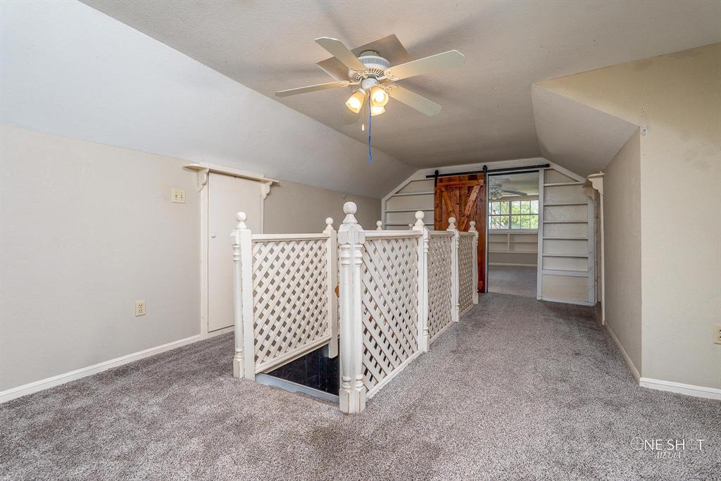 3741 Caldwell Road Abilene, TX 79601 - Photo 24 of 36 Additional living space featuring ceiling fan, lofted ceiling, a barn door, and carpet