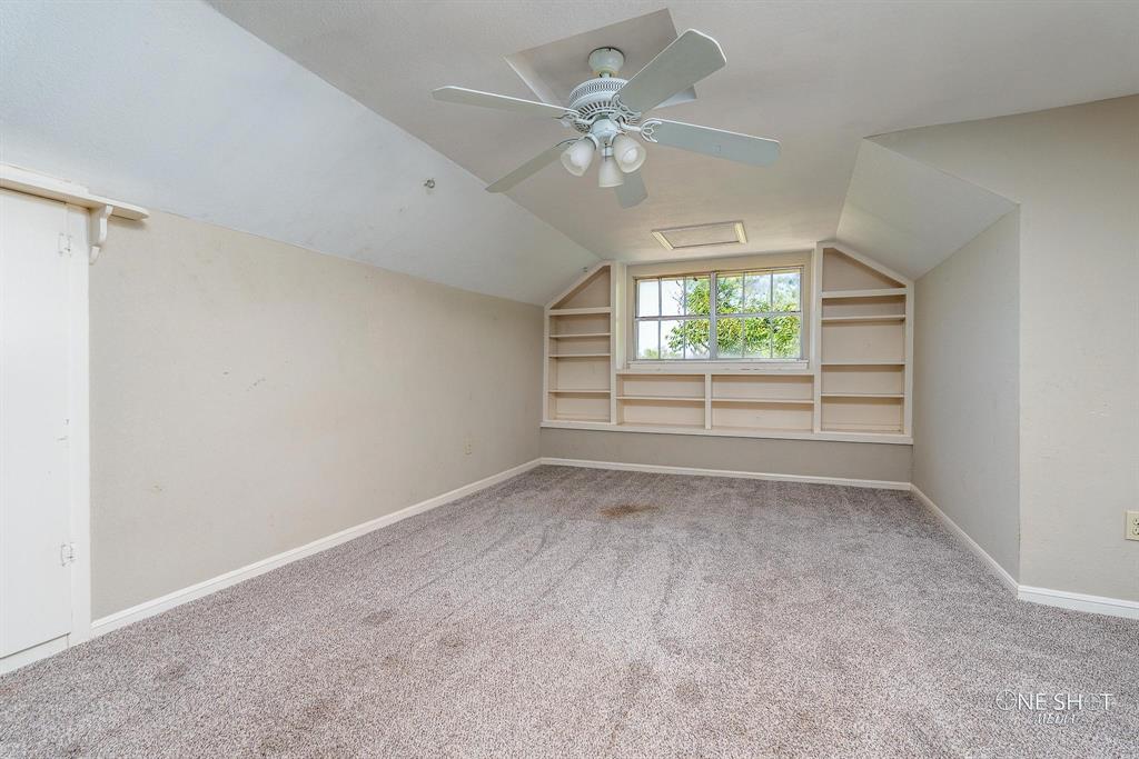 3741 Caldwell Road Abilene, TX 79601 - Photo 25 of 36 Bonus room featuring built in shelves, vaulted ceiling, ceiling fan, and carpet flooring